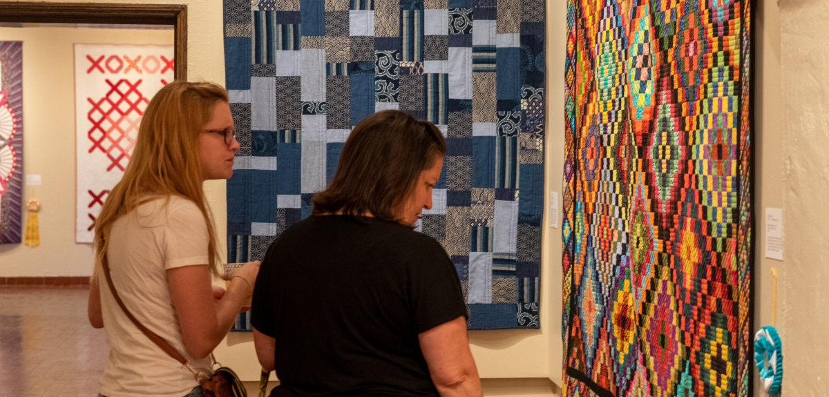 Image of museum visitors admiring quilts from the quilt show